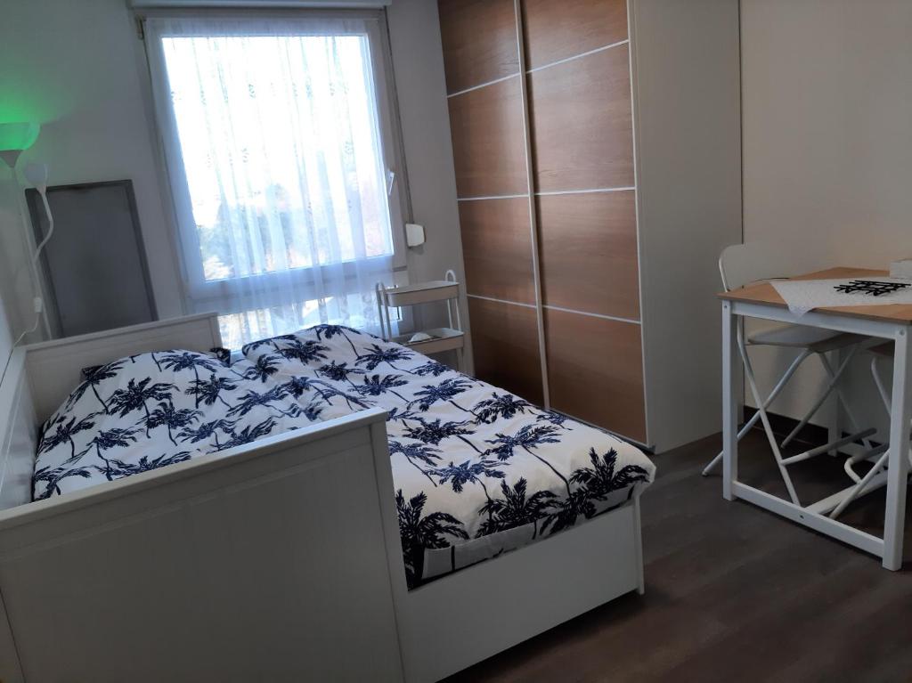 une petite chambre avec un lit et un bureau dans l'établissement Riadh, à Strasbourg