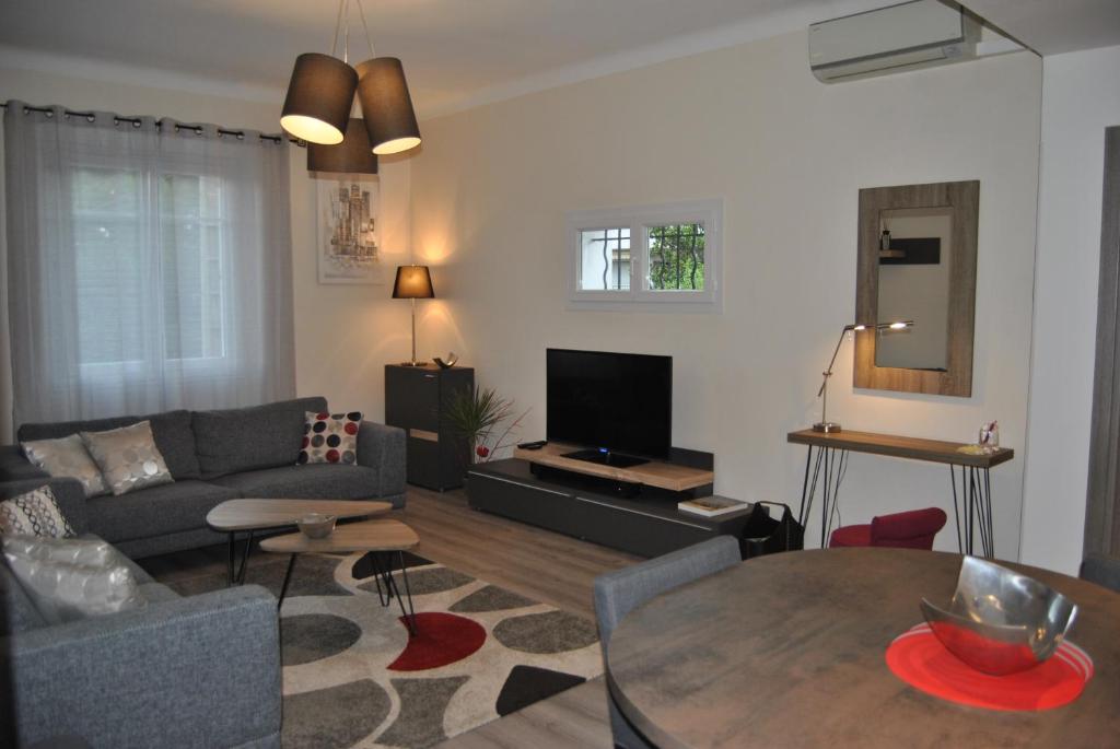 a living room with a couch and a table at Le Calme au Centre Ville à 10 minutes à pied de la Croisette et des plages in Cannes