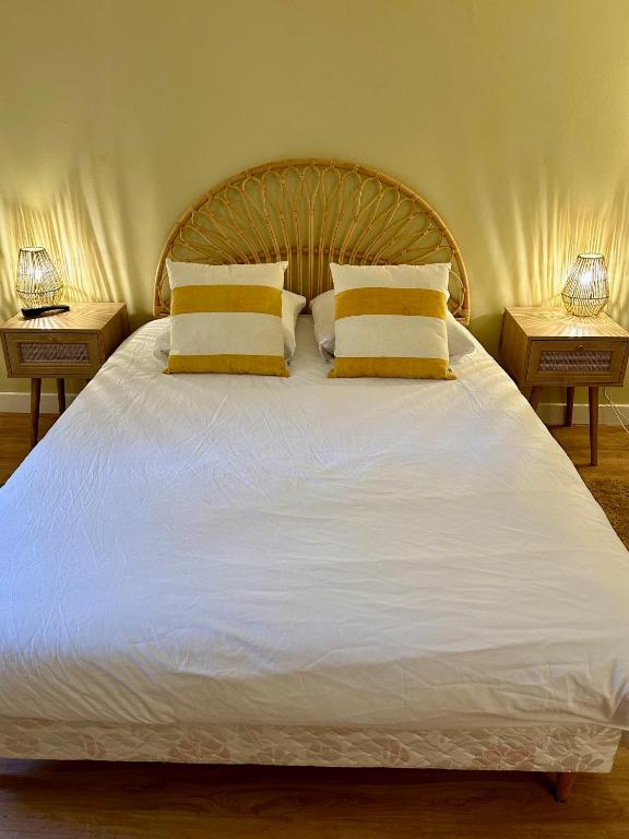 - un lit blanc avec 2 oreillers jaunes dans l'établissement Le Duplex - Gare - 4 Personnes, au Mans