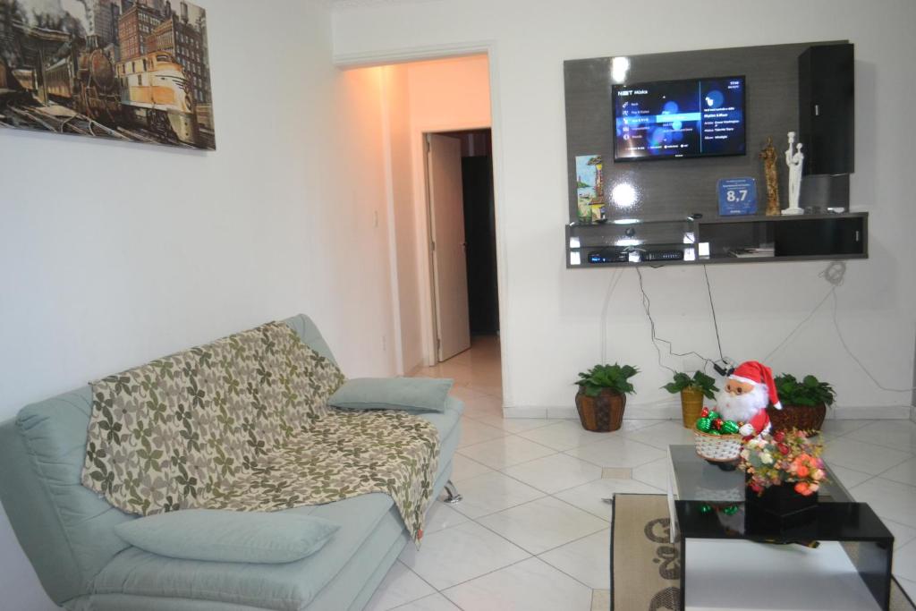 ein Wohnzimmer mit einem Sofa und einem TV in der Unterkunft Apartamento no Centro in Florianópolis