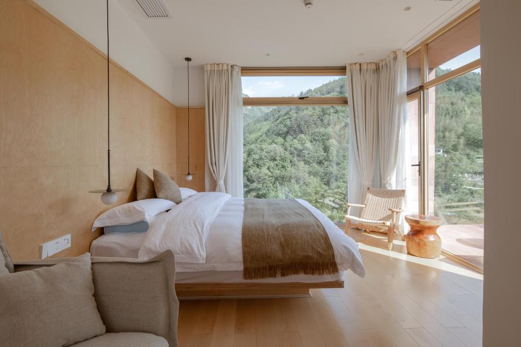兴隆Vretreats Suyunjian Boutique Hotel的一间带床和大窗户的卧室