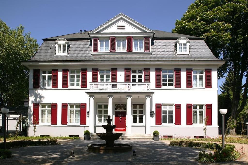Una casa roja y blanca con una fuente delante de ella. en die Villa, Zimmer 23, EZ, en Leverkusen
