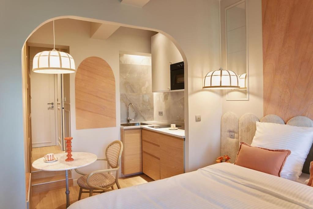 une chambre avec un lit et une table et une cuisine dans l'établissement Hermes Room - Duke Housing, à Paris