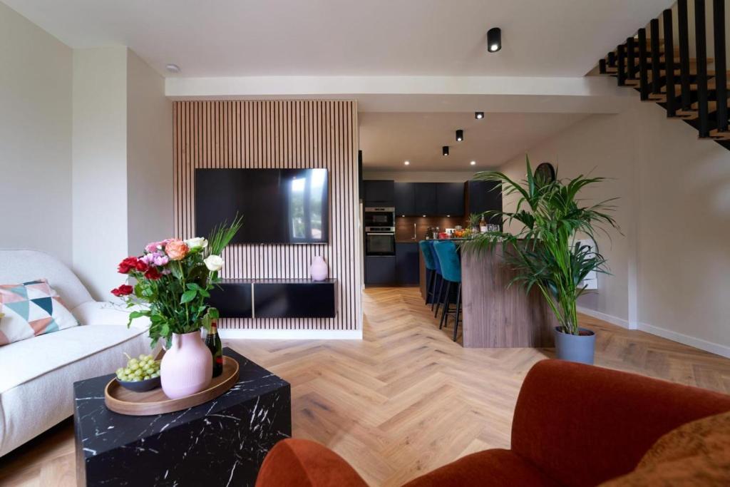 un salon avec un canapé et une table avec des fleurs dans l'établissement Le Nid Suspendu-insolite-wifi-clim, à Toulon