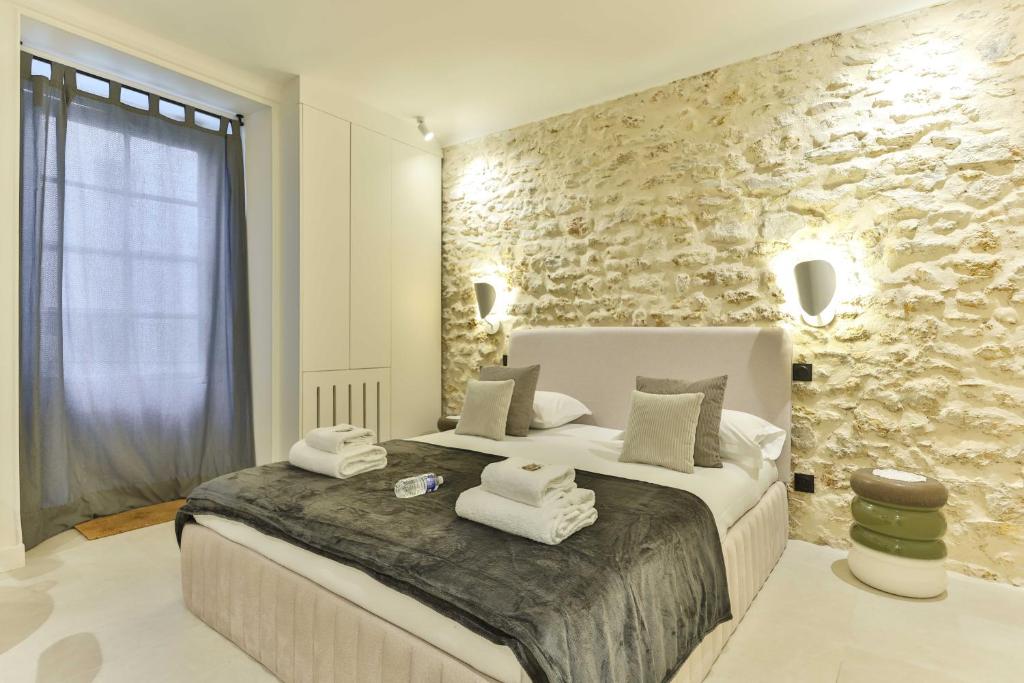 une chambre avec un grand lit avec des serviettes dessus dans l'établissement Beautiful 1-bedroom apartment 2pers rue du commerce Eiffeil Tower, à Paris