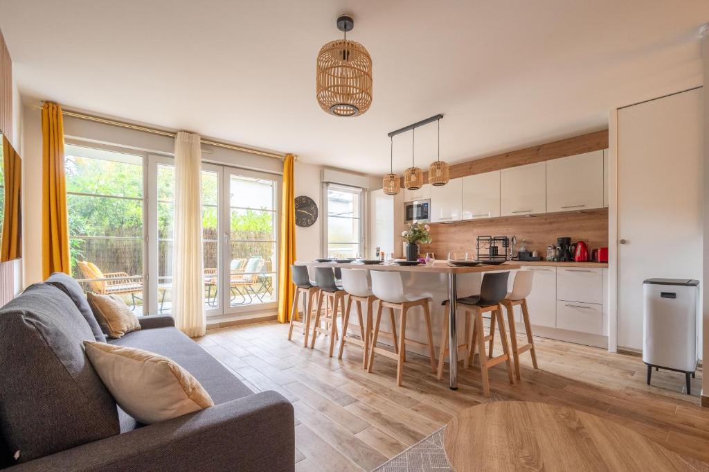 une cuisine et un salon avec un canapé et une table dans l'établissement Disneyland-Charmant appartement 8 personnes-Terrasse-Gare-Parking, à Montévrain