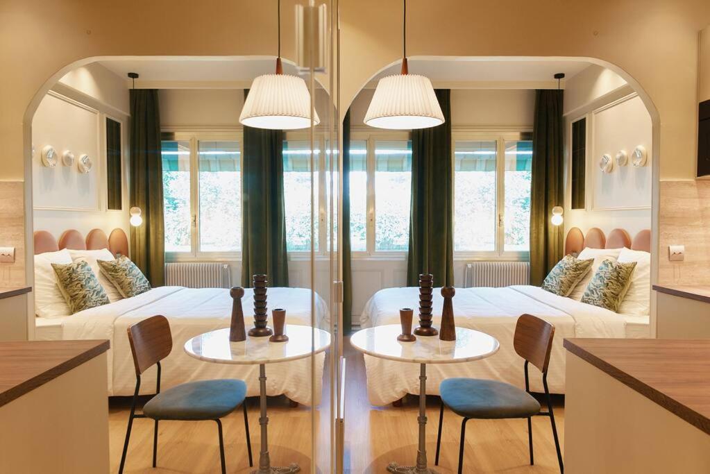 - une chambre avec 2 lits et 2 tables et chaises dans l'établissement Saint Charles Room - Duke Housing, à Paris