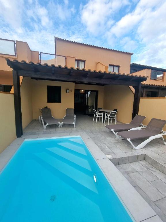 a villa with a swimming pool and a house at Granillo Beach Calm in Costa Calma