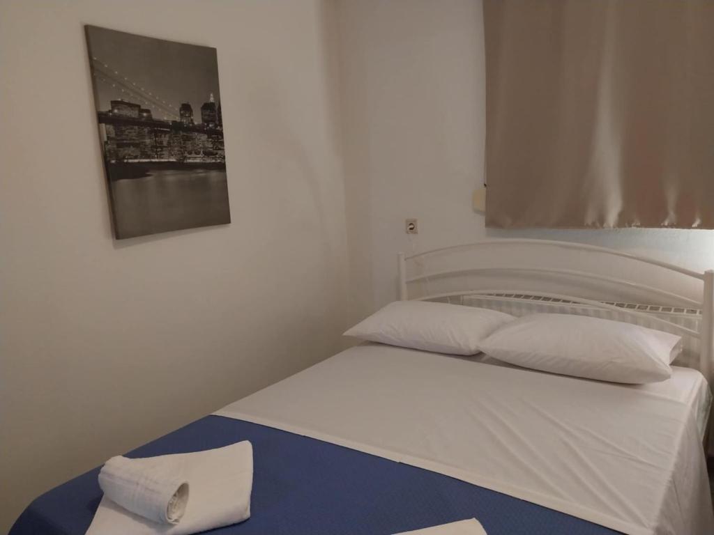a white bed in a bedroom with a picture on the wall at Ntolos House Old Town in Kavala