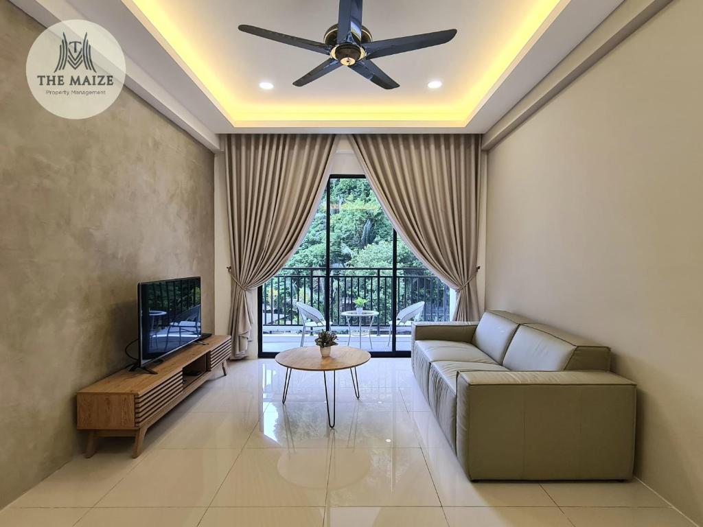 a living room with a couch and a ceiling fan at The Cove Hillside Residence Ipoh-Nature On Earth in Ipoh