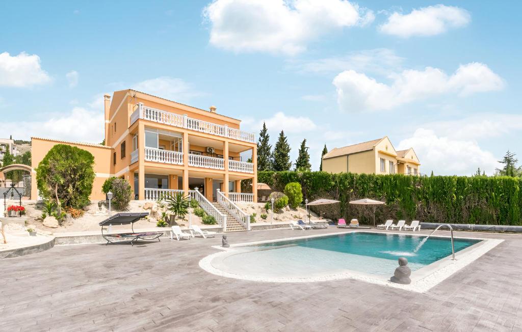 una villa con piscina di fronte a un edificio di Villa Carmela a Baena