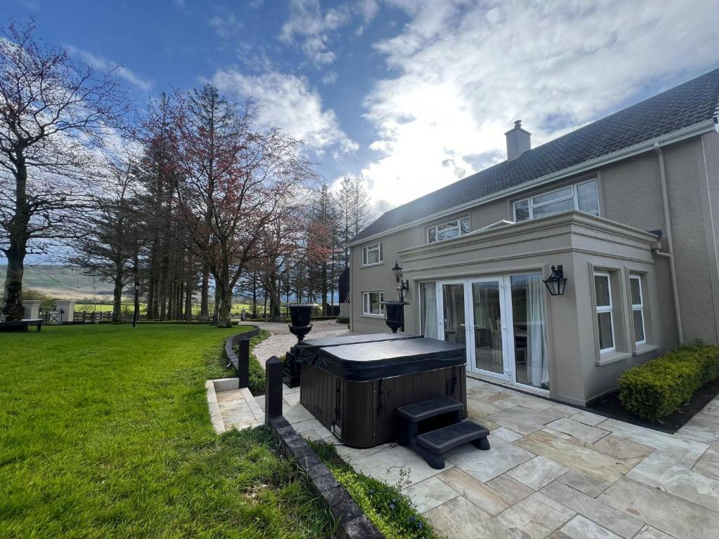 a house with a hot tub in the yard at Ballyness Lodge in Derry Londonderry