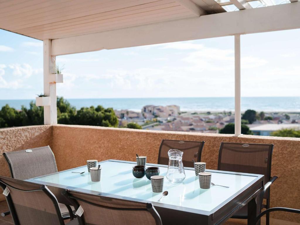 - une table sur un balcon avec vue sur l'océan dans l'établissement Pavillon 3 pièces, 6 pers, vue mer, clim, animaux, parking - FR-1-409-101, à Fleury