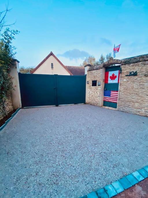 un garage avec une porte bleue arborant un drapeau canadien dans l'établissement Gîte du Cap Romain, à Bernières-sur-Mer