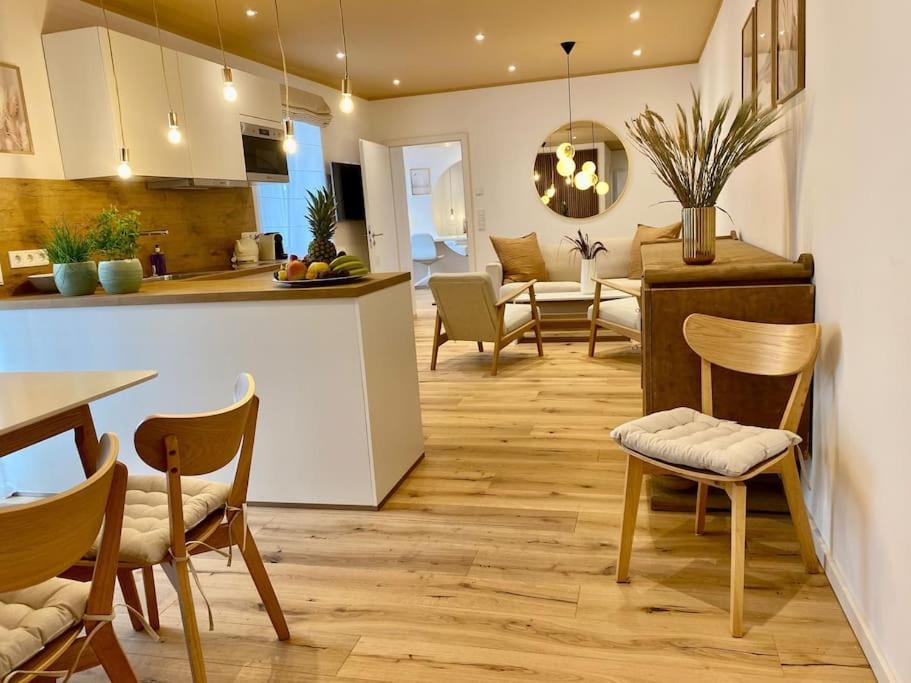a kitchen and living room with a table and chairs at Komfort - Suite zentral, mit Balkon und Waschmaschine in Düsseldorf