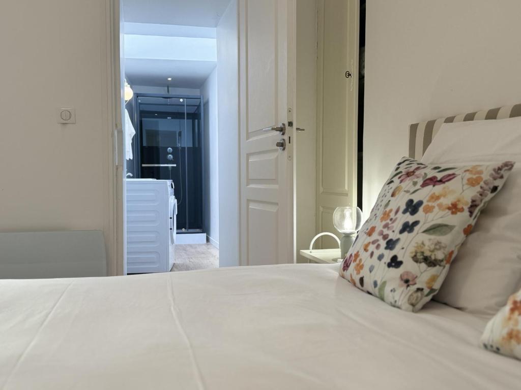 - une chambre avec un lit blanc et un oreiller dans l'établissement Les lys jaunes - 4pers - Rêve au Mans, au Mans