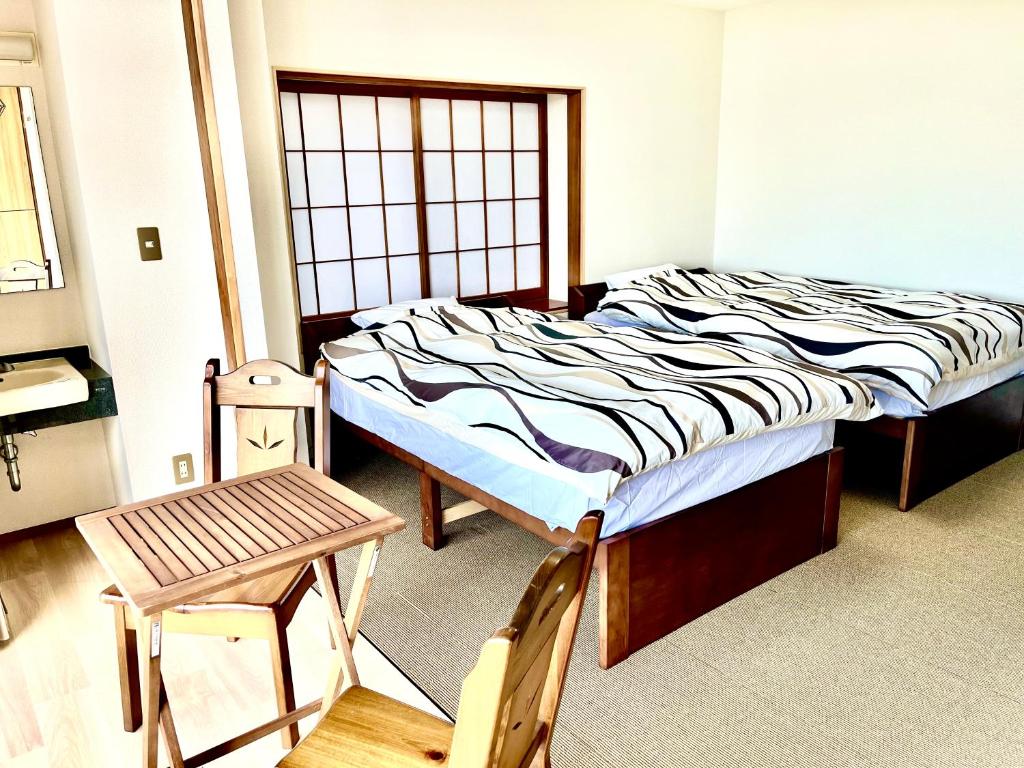 Postel nebo postele na pokoji v ubytování ジェムスティーイン川奈
