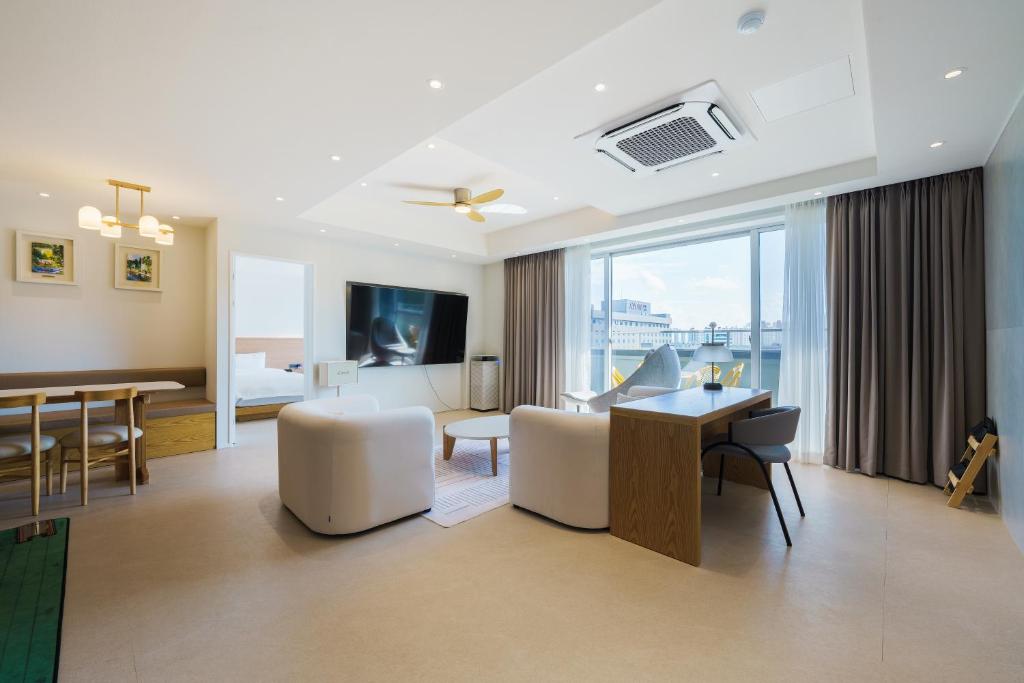 a living room with a desk and a dining room at Gran Hotel in Gunsan