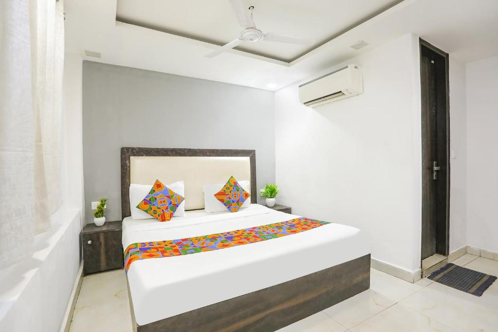 a white room with a bed with colorful pillows at Via The Arrow in New Delhi