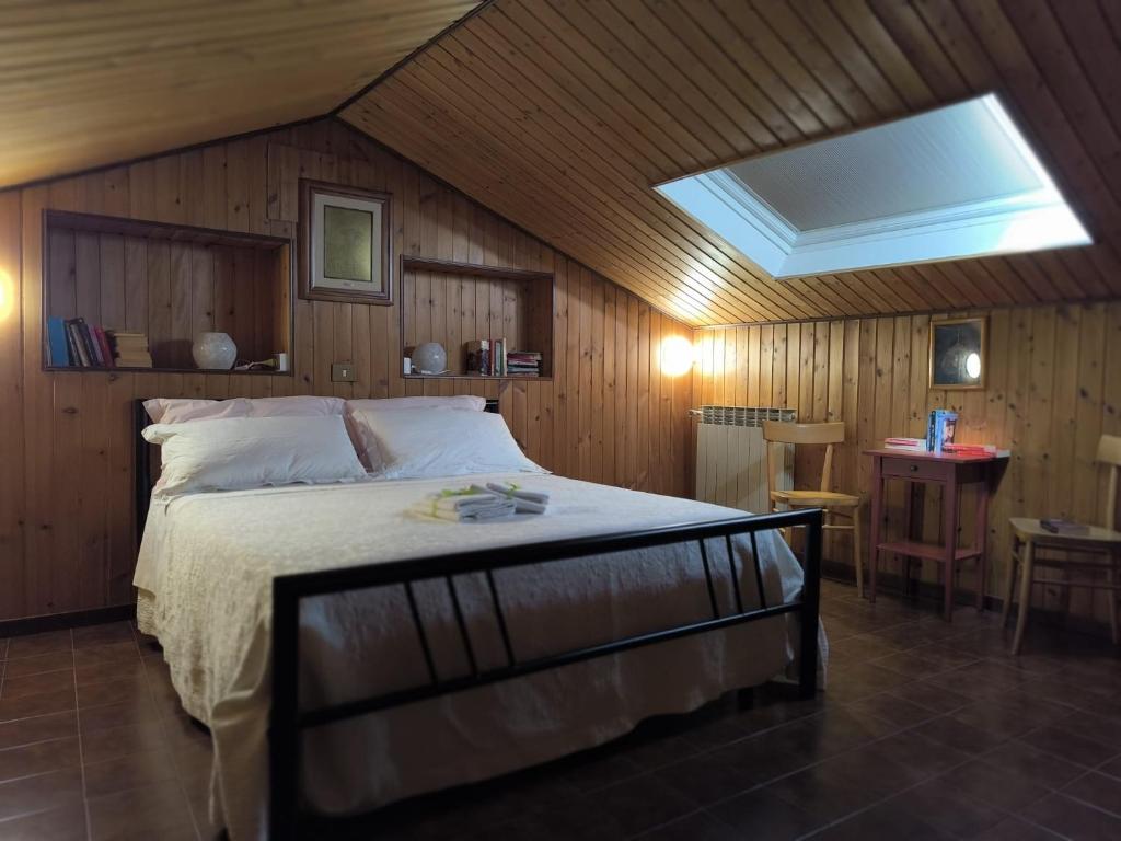 a bedroom with a bed in a room with wooden walls at La Casa Dei Nonni in Gubbio