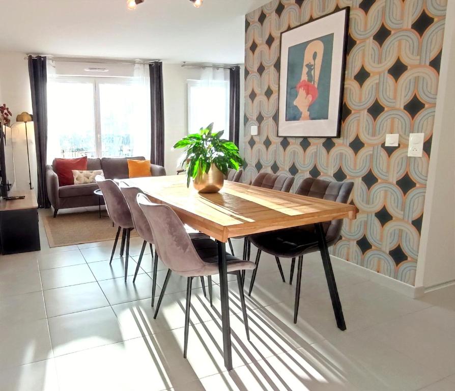 een eetkamer met een houten tafel en stoelen bij Disney Ratatouille Paris 5mn park & Val d'Europe in Chessy