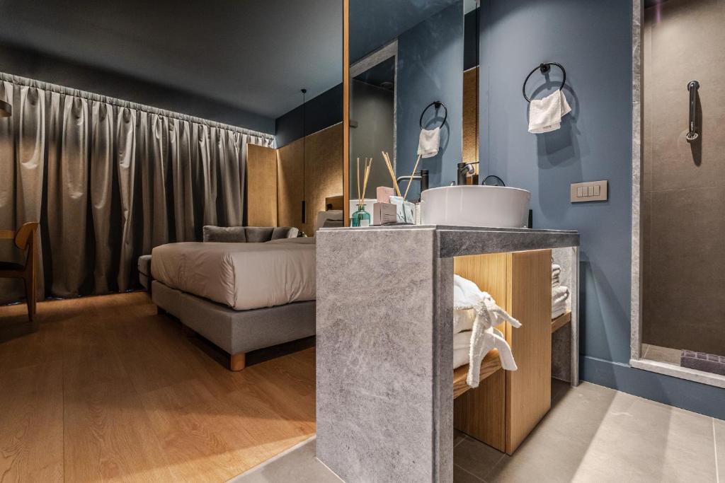 a bathroom with a sink and a bed in a room at Magnes Hotel in Volos