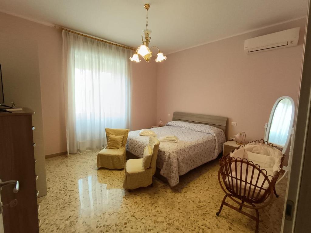 a bedroom with a bed and a chair and a window at Domus Lineker in Venafro