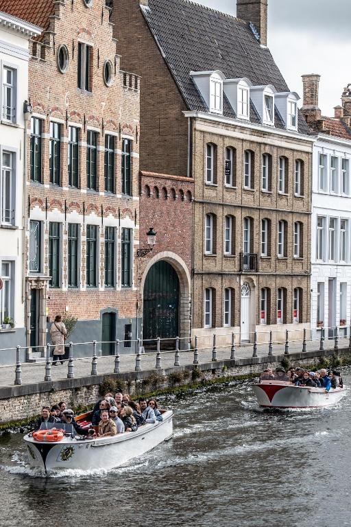 a group of people riding in boats down a river at Quay17 in Bruges