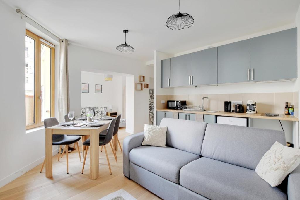 un salon et une cuisine avec un canapé et une table dans l'établissement Flexliving - Studio - Fessart, à Paris