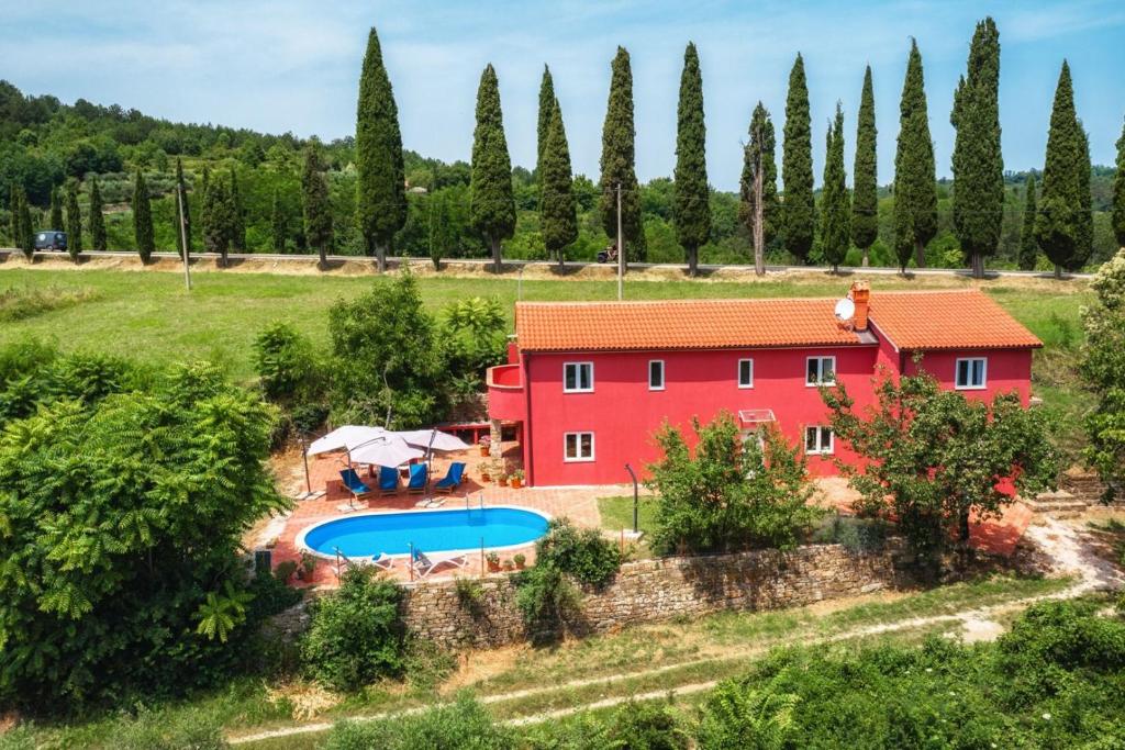 an aerial view of a red house with a swimming pool at Villa Mamma Mia in Oprtalj
