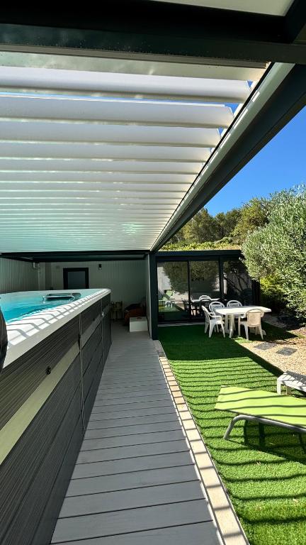 une terrasse avec une piscine et une table dans l'établissement Aloha Studio &SPA en bordure de garrigue, à Fleury