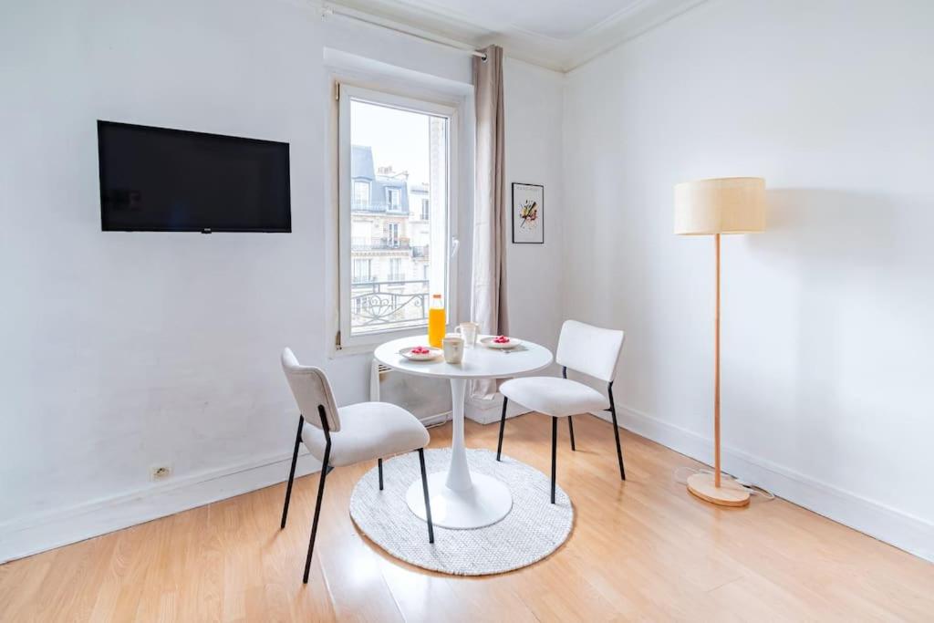 une salle à manger blanche avec une table et des chaises dans l'établissement Charmant Studio Proche Nation, Paris - II, à Paris