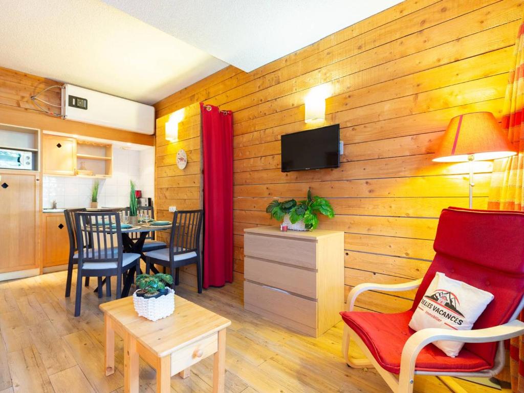 Cette chambre est dotée d'un mur en bois avec des chaises et une table. dans l'établissement Appartement rénové avec sauna, piscine, et parking à Saint Lary Village - 4 pers - FR-1-296-371, à Saint-Lary-Soulan