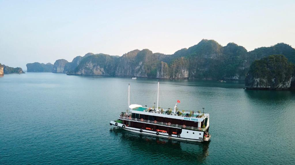 un barco en un gran cuerpo de agua en ADUTA CRUISE, en Cat Ba