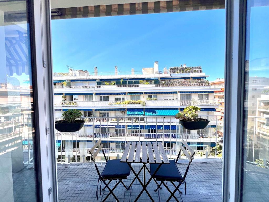 une table et des chaises devant un grand bâtiment dans l'établissement B030 Grand studio renove spacieux et lumineux, au Cannet