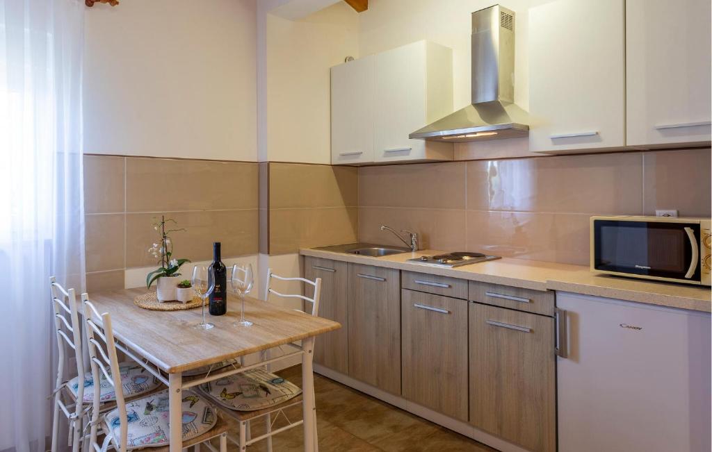 kuchnia z drewnianym stołem i kuchenką mikrofalową w obiekcie Lovely Home In Skicini With Wifi w mieście Juršići