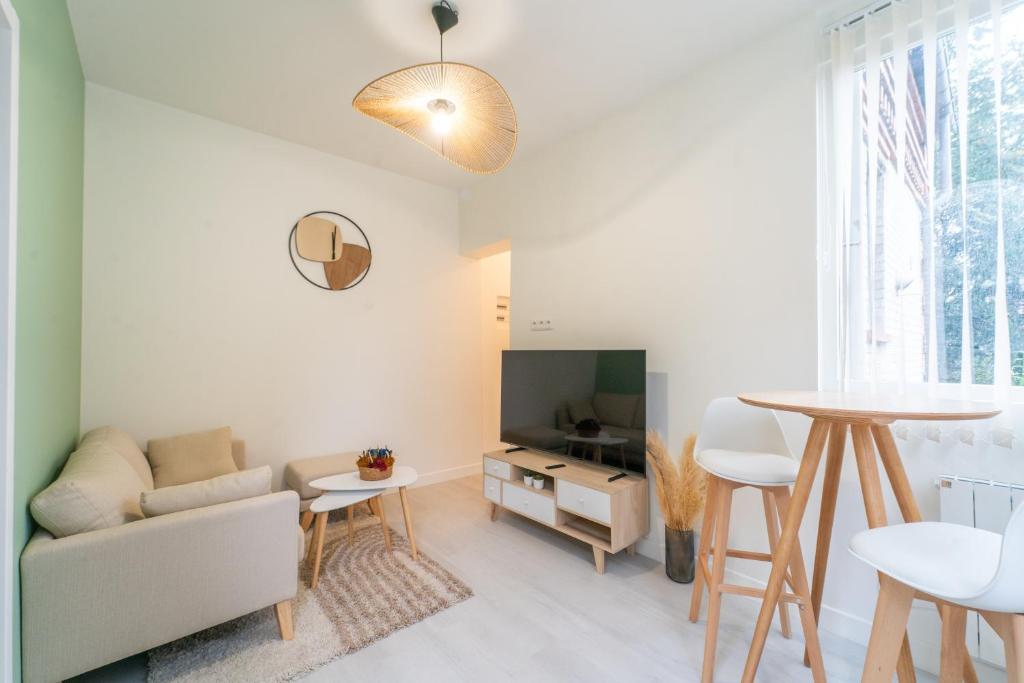 un salon avec un canapé et une table dans l'établissement Arau casa - Appt à Sannois avec jardin, à Sannois