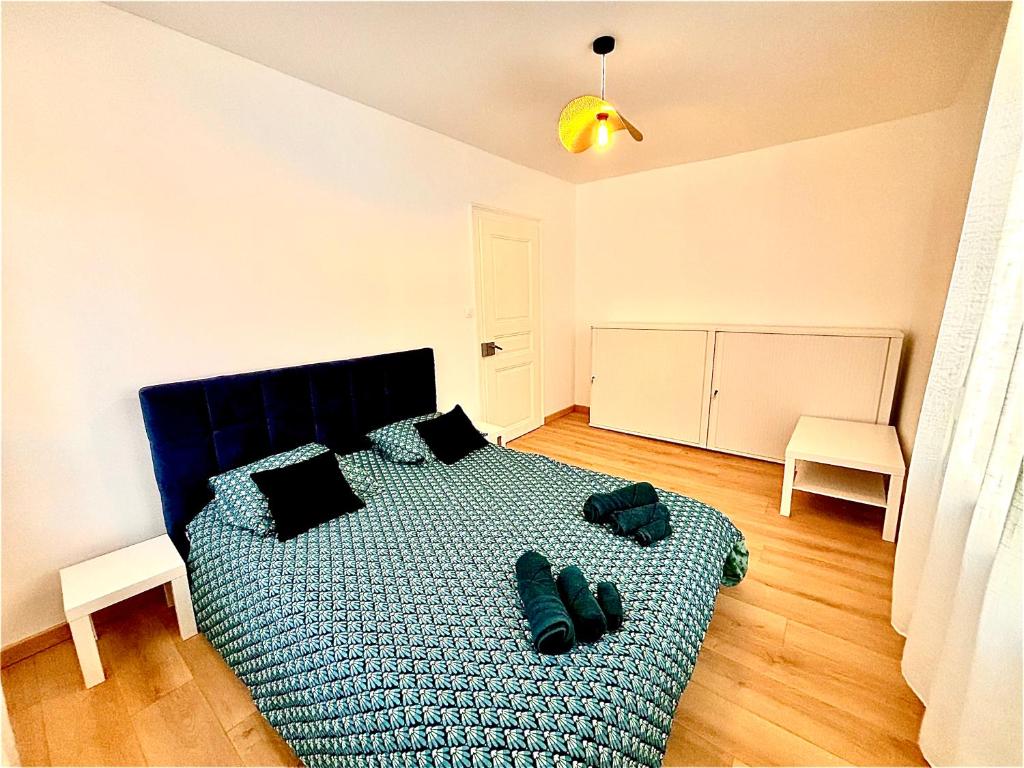 - une chambre dotée d'un lit bleu avec des chaussures dans l'établissement Charmant 2 pièces rénové, à Strasbourg