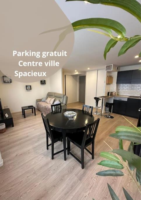 un salon avec une table et des chaises noires dans l'établissement LE DOUILLET - Parking gratuit - Centre ville, à Pau