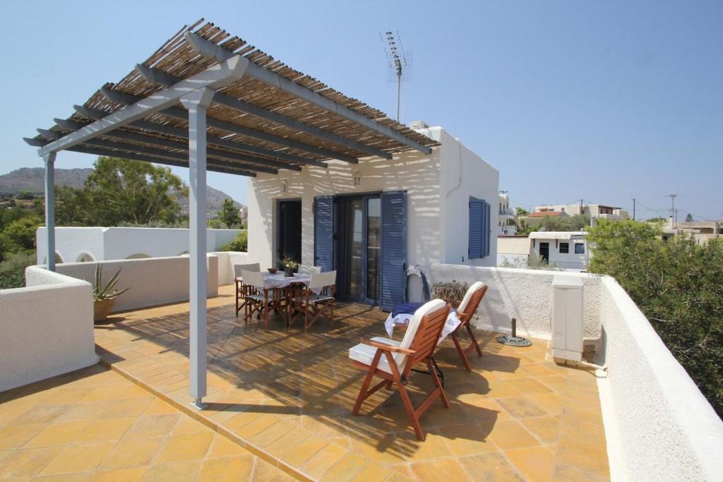 a patio with a table and chairs on a roof at Larenko by Frangki in Souvala