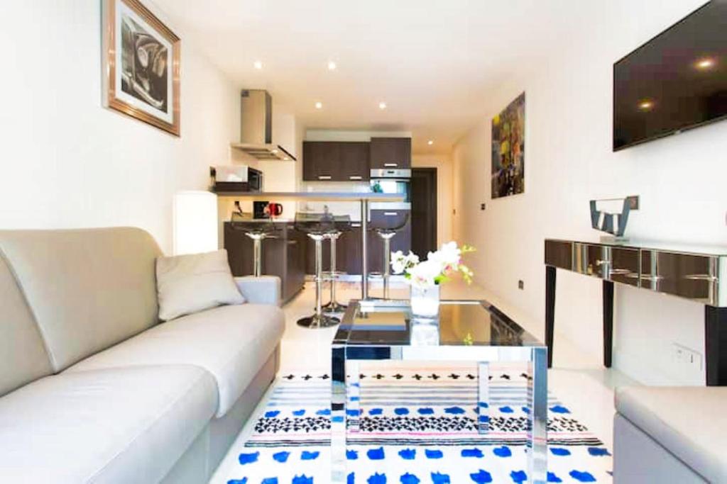 un salon avec un canapé blanc et une table en verre dans l'établissement Ref DRA by Palmes dProperties, à Cannes