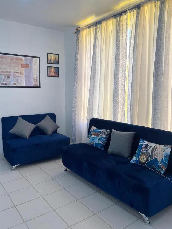 a blue couch in a living room with windows at Departamento 3Hab 7min del Centro in Tehuacán