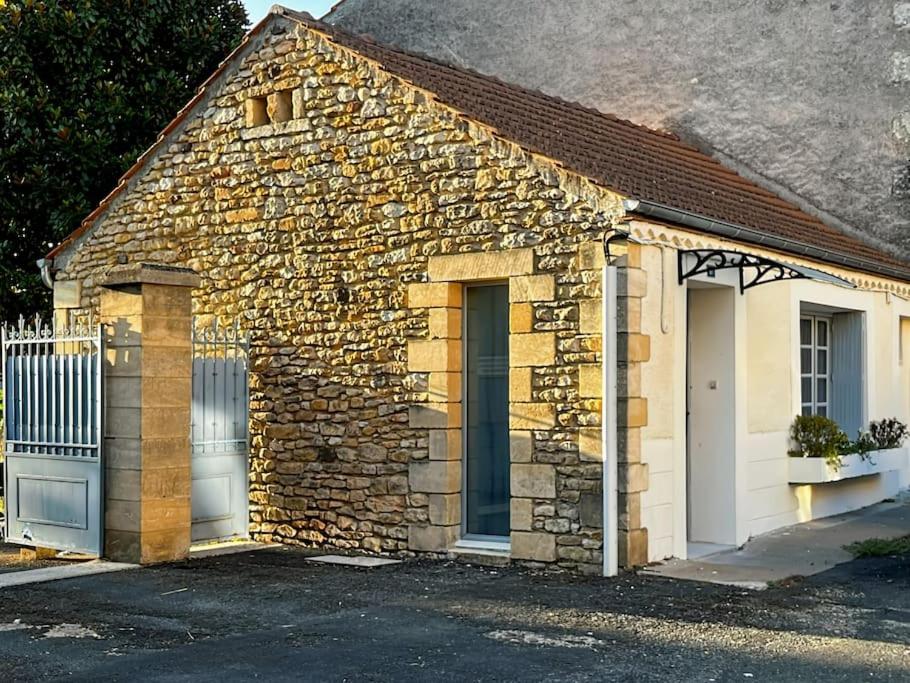 a small stone building with two doors and a fence at Gîte Uros Terrasse avec spa in Le Bugue