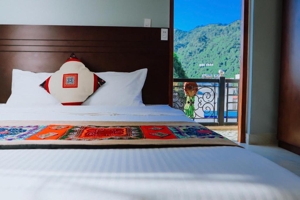 a bedroom with a bed with a view of a mountain at Khách sạn 88 mộc châu in Mộc Châu