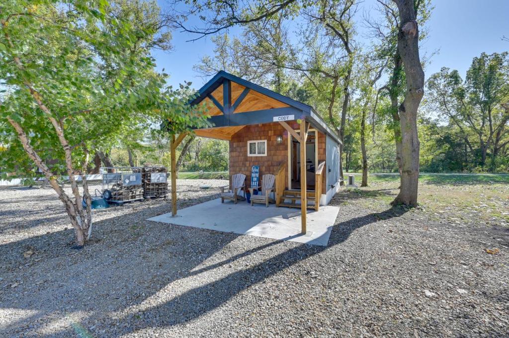 una pequeña casa en el bosque con un cobertizo en Iowa Tiny Cabin Near Pine Lake State Park, en Steamboat Rock