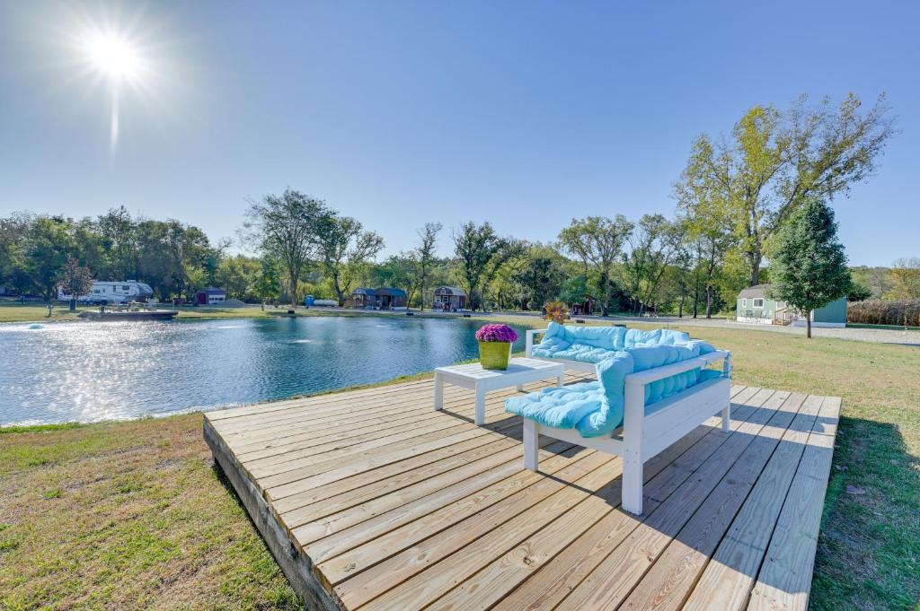 Una terraza de madera con un banco y una mesa junto a un lago. en Cabin with Trail and Pond Access in Steamboat Rock!, en Steamboat Rock