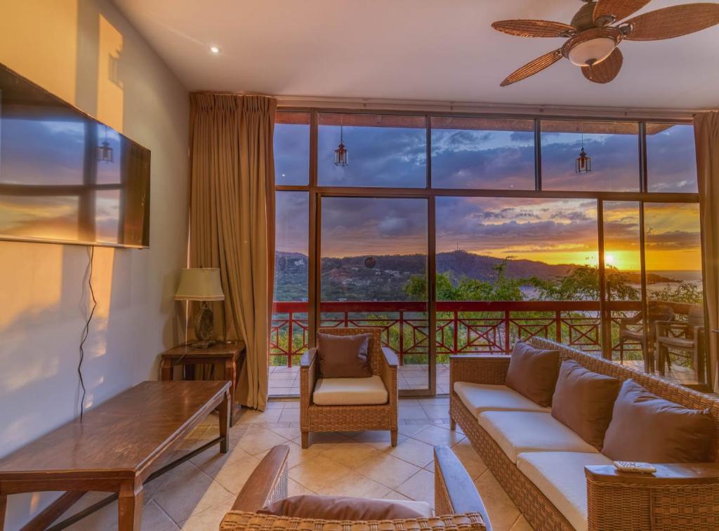 a living room with a couch and a large window at Ocean and Mountain View Villa in Playa Hermosa