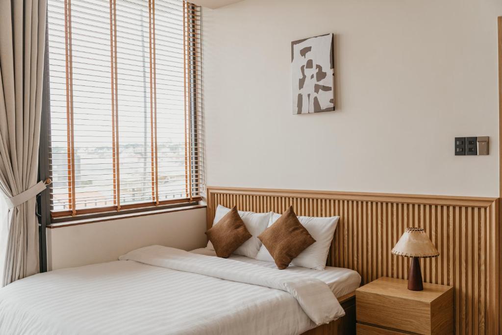 zwei Betten in einem Zimmer mit zwei Fenstern in der Unterkunft Creme Homestay Đà Lạt in Khu Chi Lăng