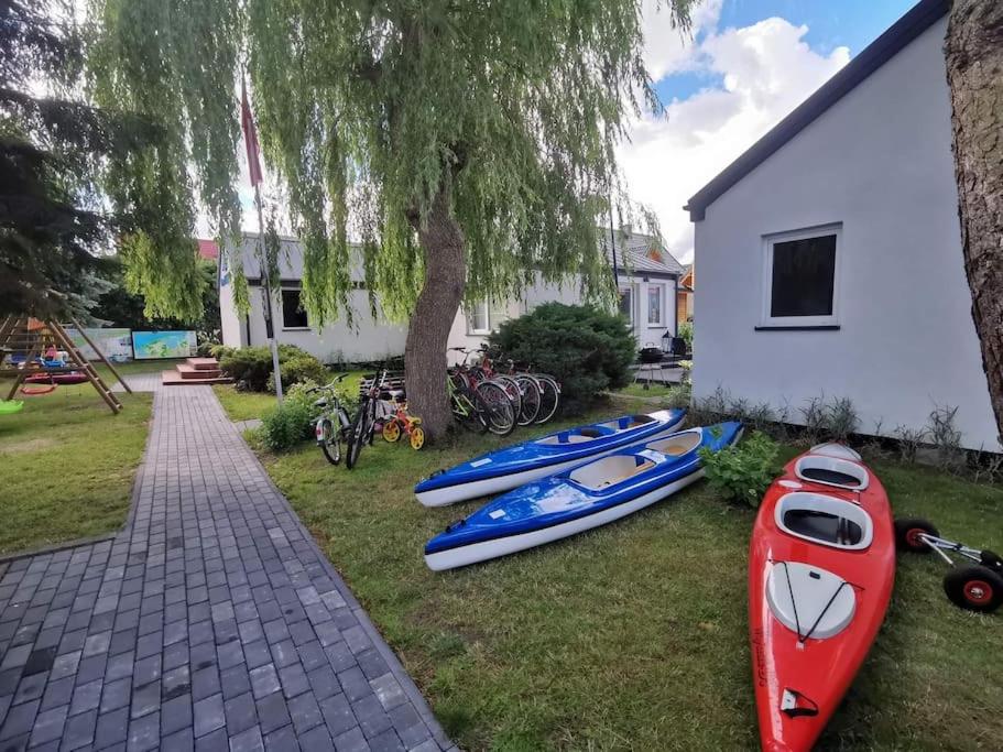 a group of kayaks on the grass next to a house at Domki Kajuta 3 in Żarnowska