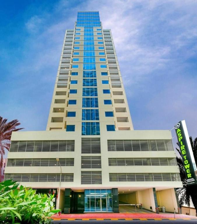 a tall white building with blue windows at Aspire Tower # Peaceful Pad Juffair in Manama